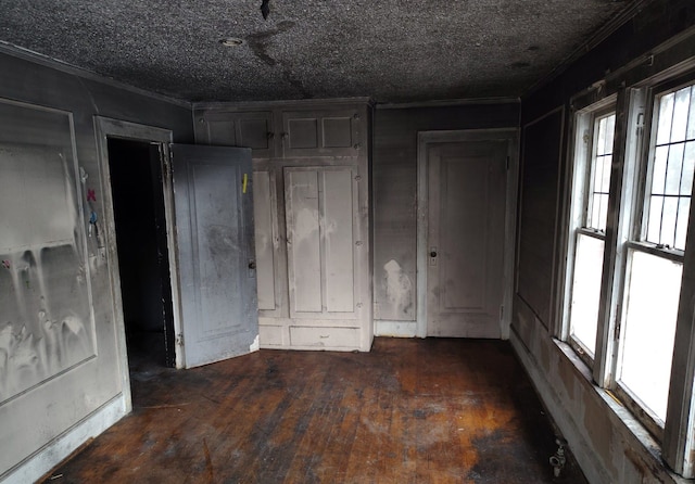 unfurnished bedroom with dark wood-type flooring and ornamental molding