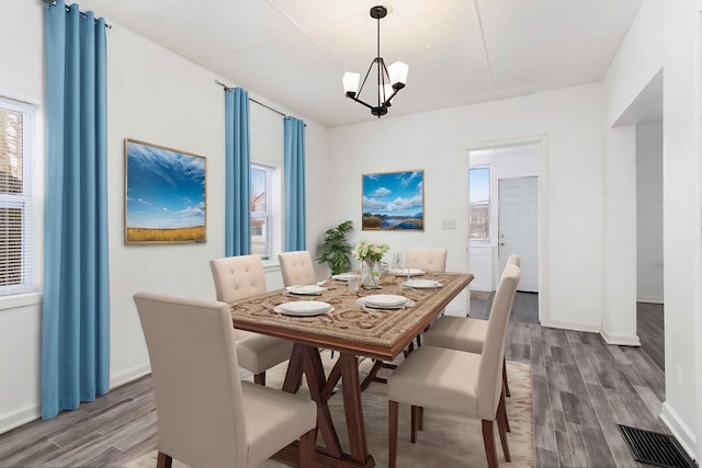 dining room with wood-type flooring and a chandelier