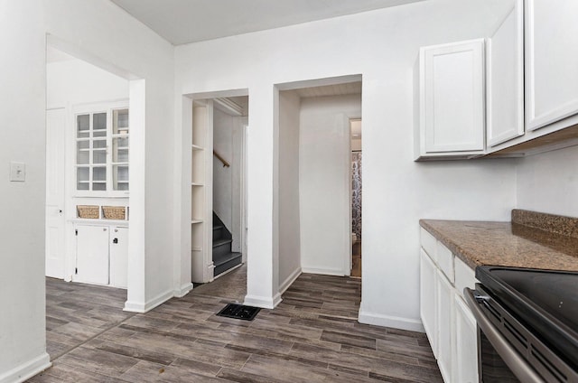 interior space featuring stone countertops, dark hardwood / wood-style flooring, and white cabinets