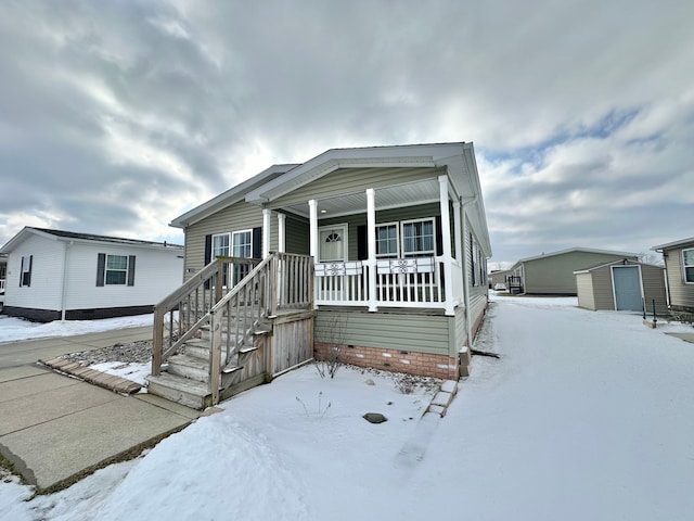 view of front of home with a porch and a shed