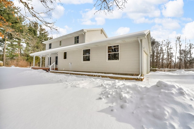 snow covered property with a garage