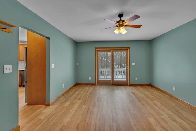 empty room with ceiling fan and light hardwood / wood-style flooring