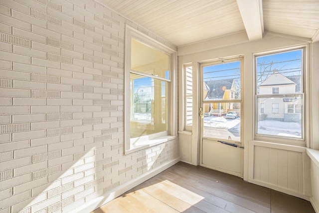 entryway with radiator, vaulted ceiling with beams, light wood finished floors, and brick wall