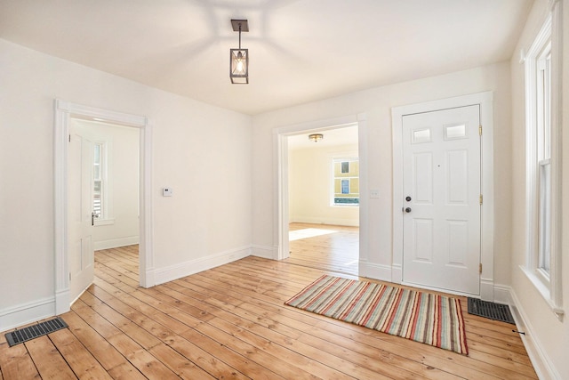 foyer featuring light wood-style flooring, visible vents, and baseboards