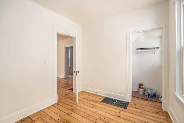 unfurnished bedroom with light wood-type flooring, baseboards, visible vents, and a closet