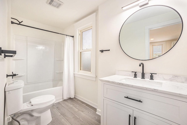 bathroom with visible vents, toilet, wood finished floors, shower / bath combination with curtain, and vanity