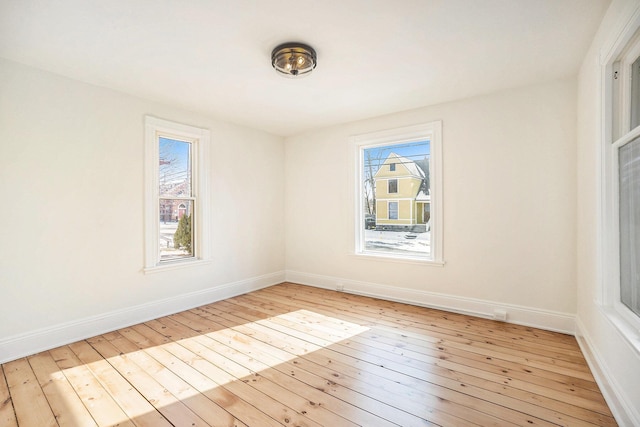 empty room with light wood finished floors and baseboards