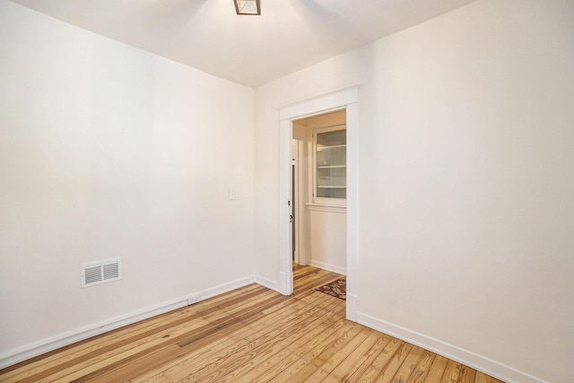 spare room featuring visible vents, light wood-style flooring, and baseboards