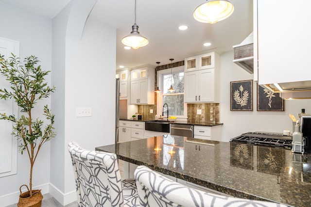 6735 S Scottdale Rd, Berrien Springs, MI 49103 - kitchen with decorative backsplash, stainless steel dishwasher, white cabinets, a sink, and a kitchen bar