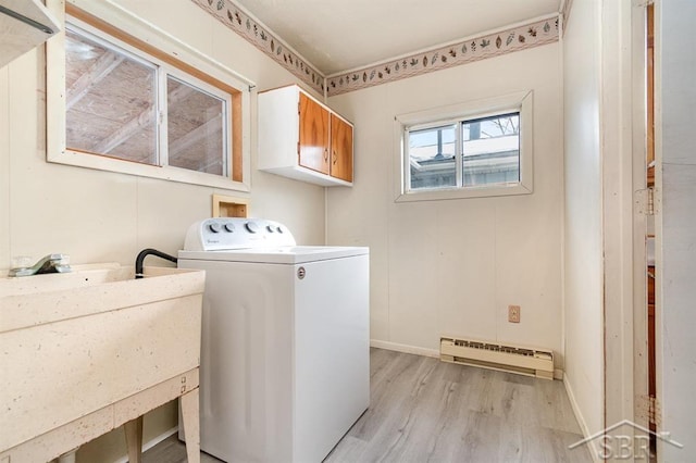 washroom with washer / dryer, sink, cabinets, baseboard heating, and light hardwood / wood-style floors