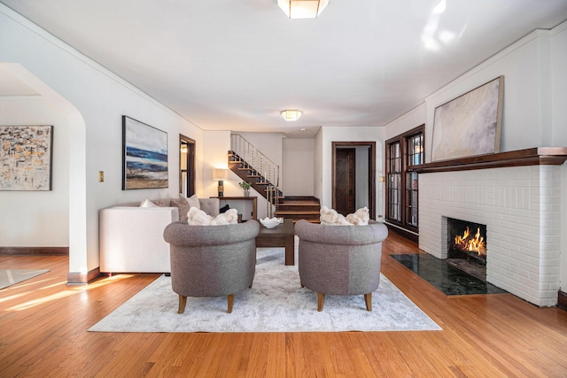 living room with a brick fireplace and hardwood / wood-style floors