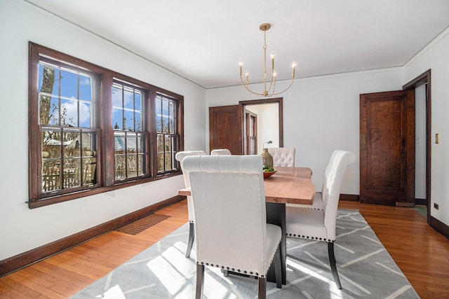 dining space with an inviting chandelier and hardwood / wood-style flooring