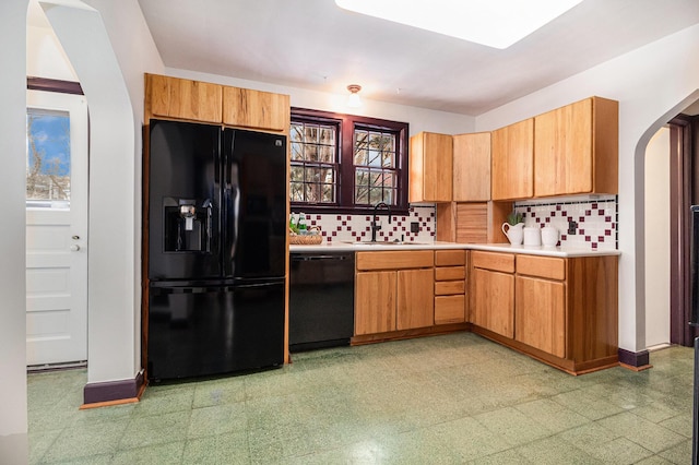 kitchen with backsplash, plenty of natural light, sink, and black appliances