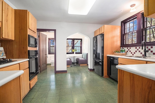 kitchen featuring tasteful backsplash, sink, and black appliances