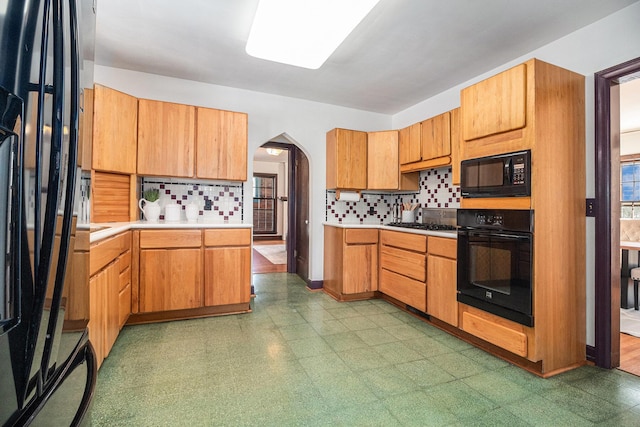 kitchen featuring backsplash and black appliances