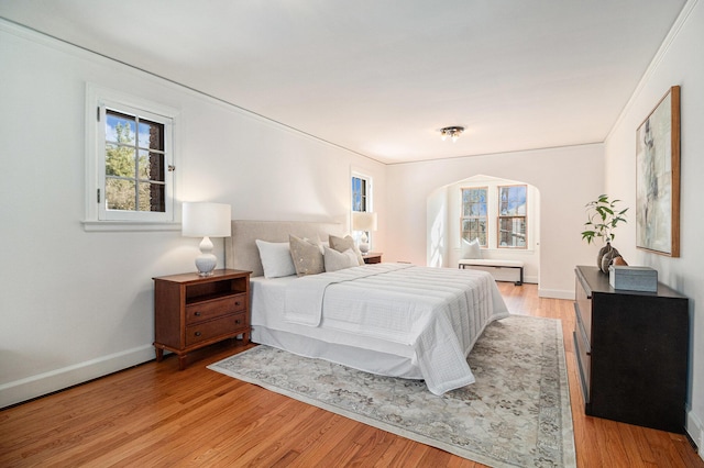 bedroom featuring ornamental molding and light hardwood / wood-style floors