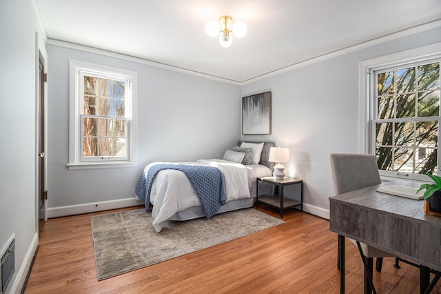 bedroom with ornamental molding and light wood-type flooring