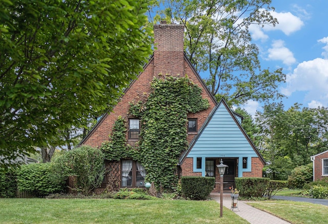 tudor-style house with a front yard