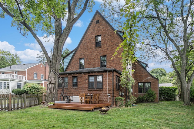 back of property featuring a deck and a lawn