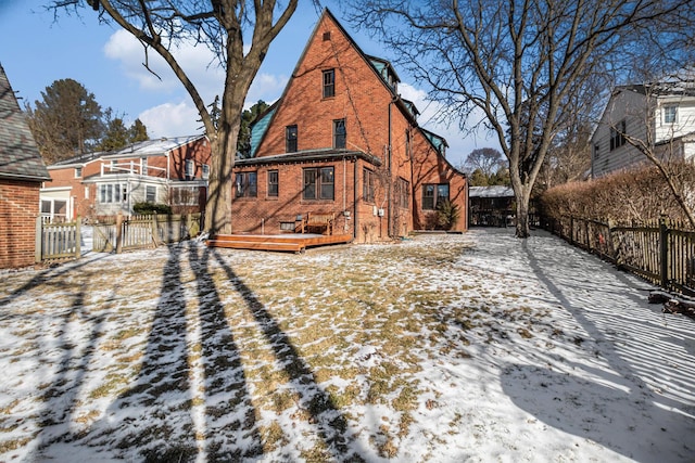 snow covered house featuring a deck