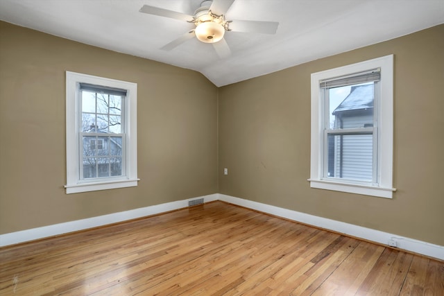 empty room with lofted ceiling, ceiling fan, and light hardwood / wood-style flooring