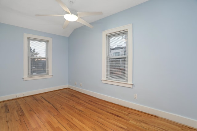 spare room featuring plenty of natural light, lofted ceiling, ceiling fan, and light hardwood / wood-style flooring