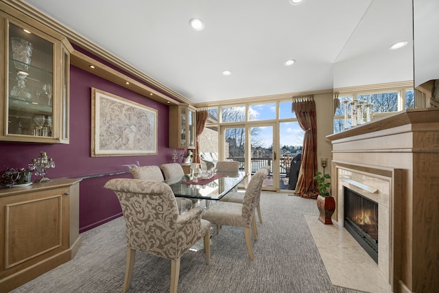 dining room featuring light colored carpet, a high end fireplace, and recessed lighting