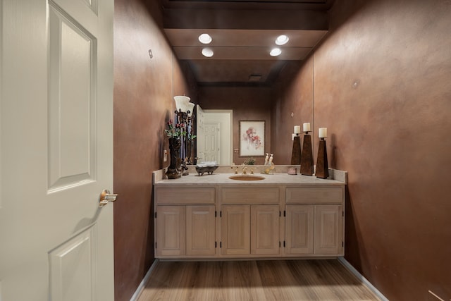 bathroom featuring vanity, baseboards, and wood finished floors