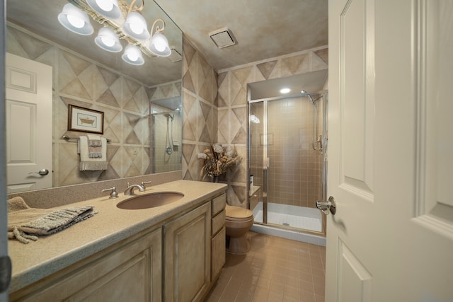 bathroom featuring tile patterned flooring, toilet, vanity, tile walls, and a shower stall