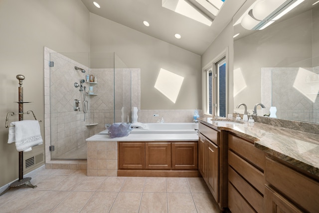 bathroom with vaulted ceiling with skylight, a garden tub, tile patterned flooring, vanity, and a shower stall