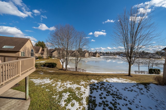 yard covered in snow featuring a water view