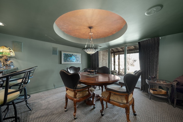 dining area featuring a tray ceiling, carpet flooring, visible vents, and baseboards