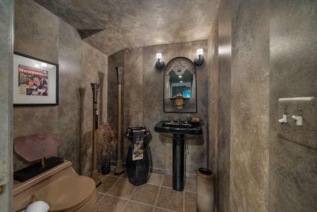 half bathroom with toilet and tile patterned floors