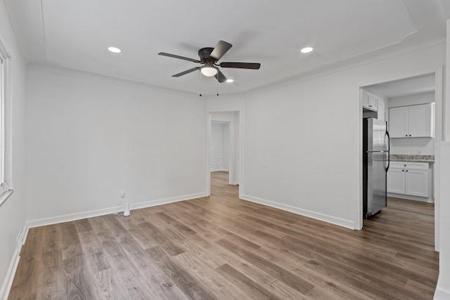 spare room with ornamental molding, ceiling fan, and light hardwood / wood-style flooring