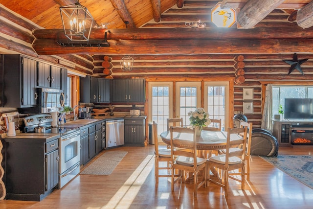 kitchen with appliances with stainless steel finishes, hanging light fixtures, beam ceiling, a notable chandelier, and light hardwood / wood-style floors