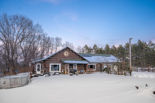 view of snow covered back of property