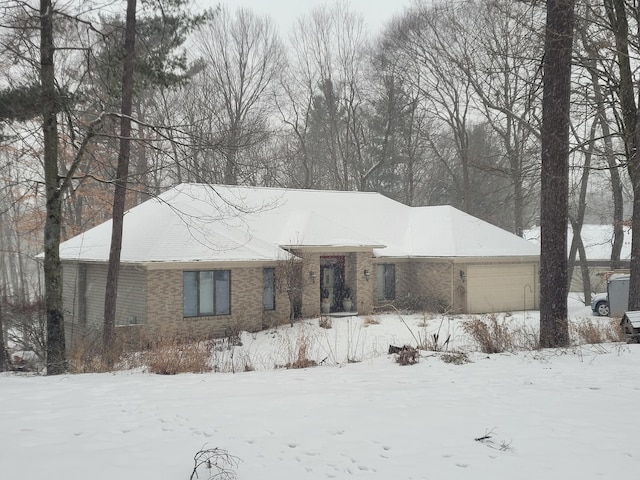 view of front facade with brick siding and a garage