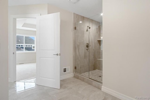 bathroom featuring a shower with door