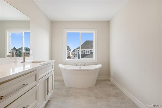 bathroom featuring a washtub and vanity