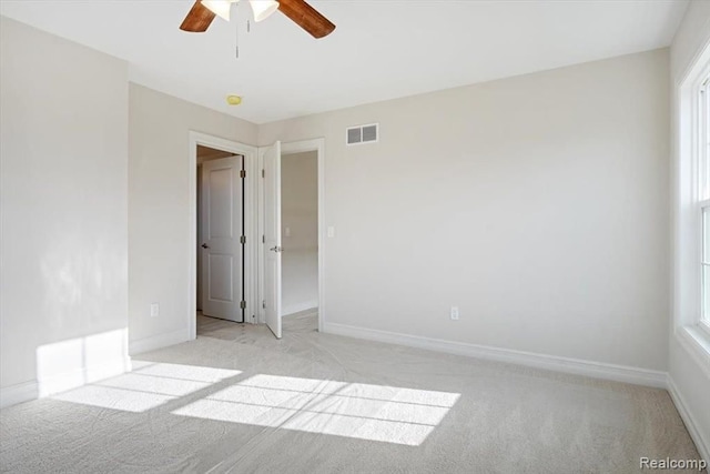 carpeted spare room with ceiling fan