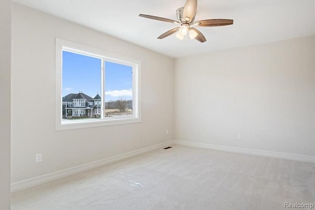 empty room featuring light colored carpet and ceiling fan