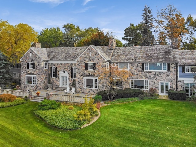 view of front of home featuring a wooden deck, a front lawn, and french doors