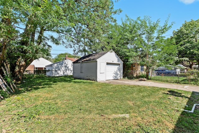 view of yard featuring a garage and an outbuilding