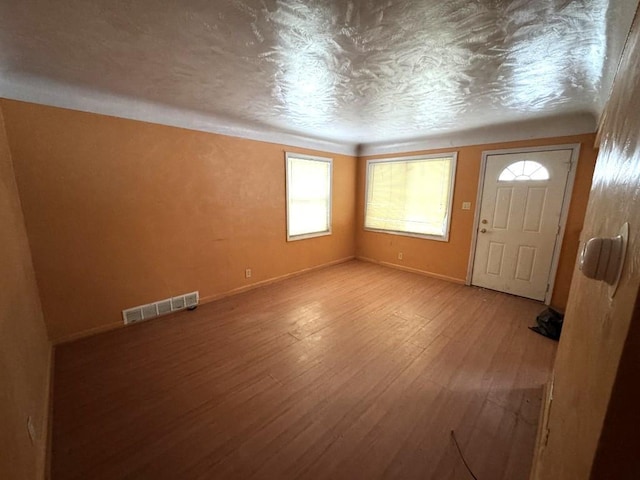 entryway featuring a textured ceiling and light hardwood / wood-style flooring