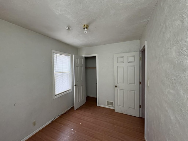 unfurnished bedroom featuring hardwood / wood-style flooring and a closet