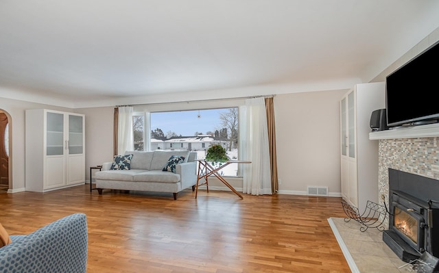 living room with a fireplace and light wood-type flooring