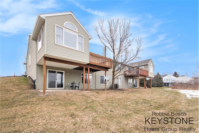 back of house featuring a wooden deck, a patio area, and a lawn