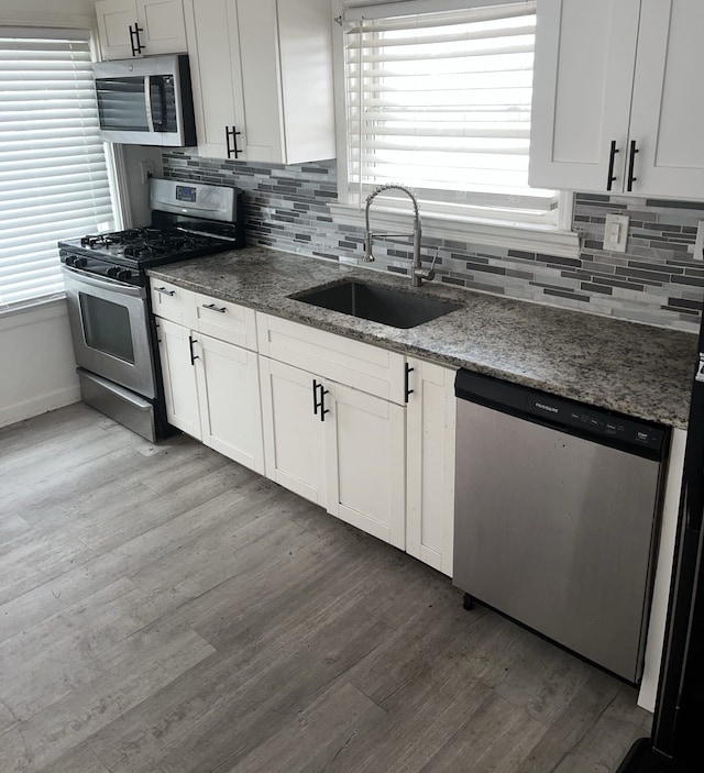 30052 Schoenherr Rd, Warren, MI 48088 - kitchen with backsplash, light wood-type flooring, appliances with stainless steel finishes, and a sink