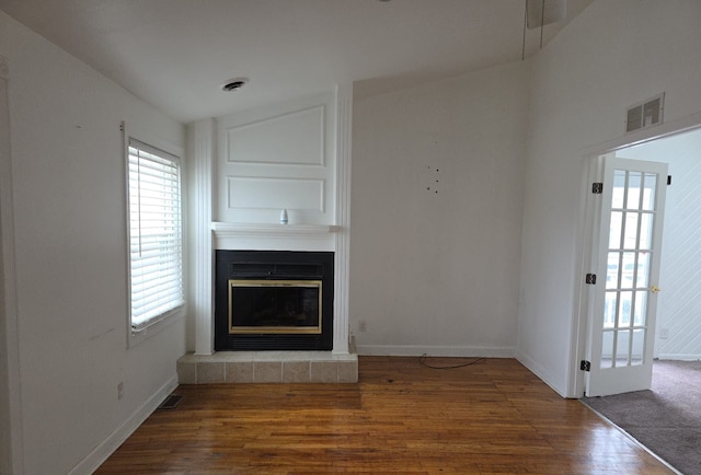 30052 Schoenherr Rd, Warren, MI 48088 - unfurnished living room featuring a glass covered fireplace, wood finished floors, visible vents, and baseboards
