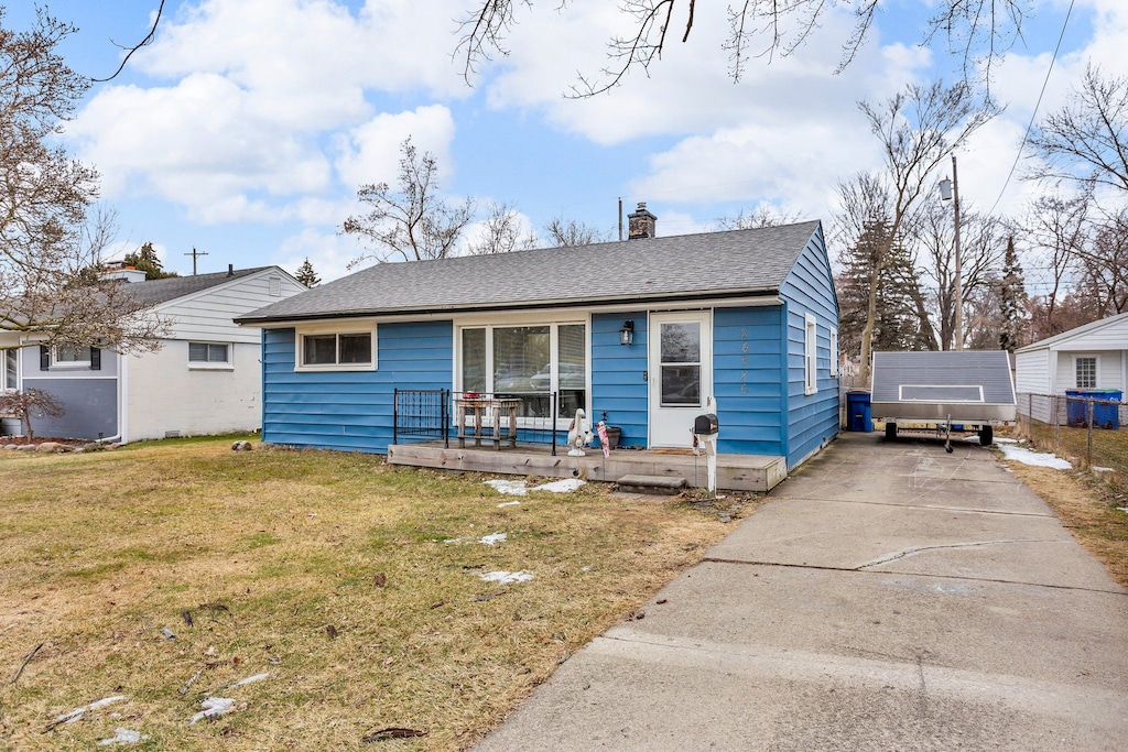 view of front of home with an outbuilding, covered porch, and a front yard